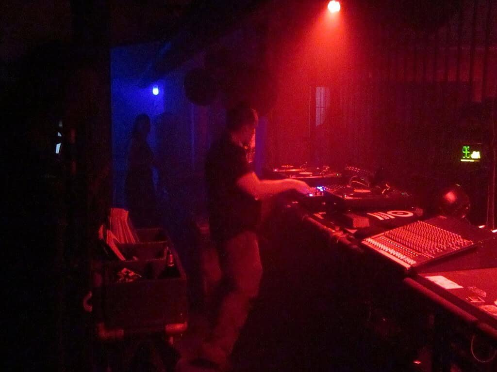 Techno Genres and Subgenres: 12 Types of Techno Explained (2026) 4 A DJ playing in red light inside the Tresor techno club in Berlin, 2015