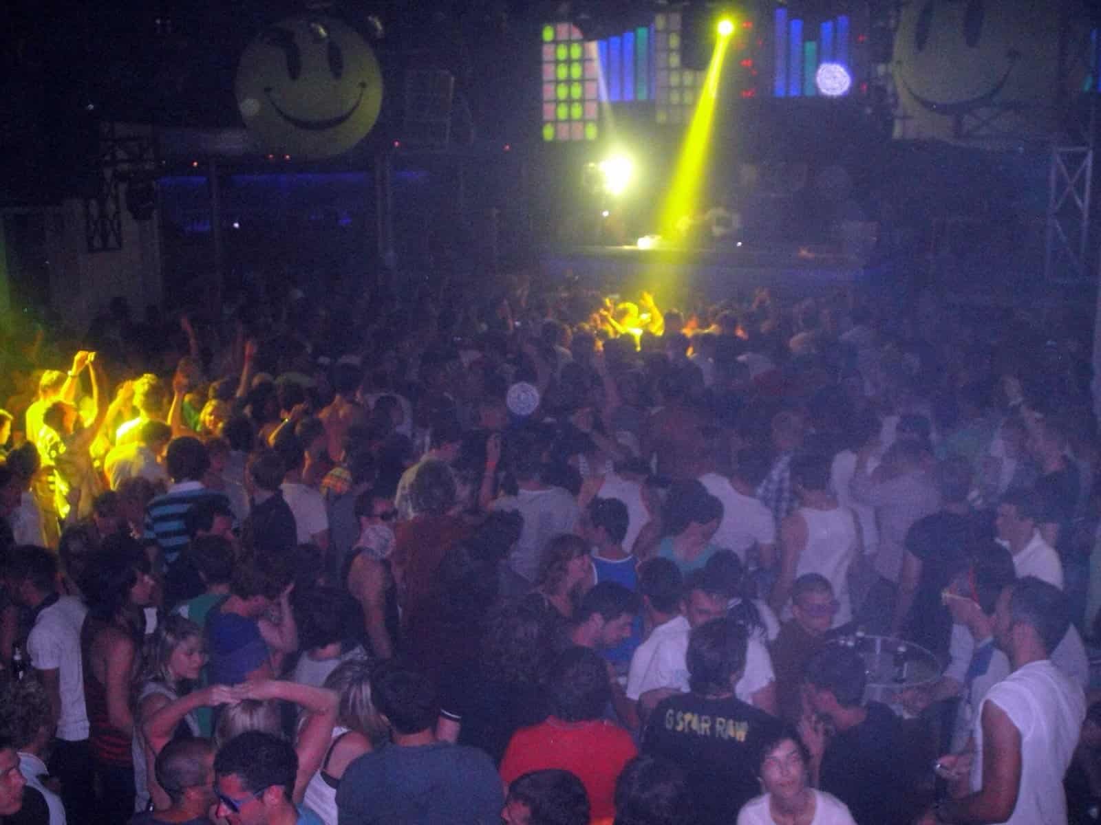 The Best Techno DJ Sets of All Time: 10 Sets That Made History 2 Packed dancefloor at Space Ibiza under smiley face decorations during a Carl Cox night in 2009