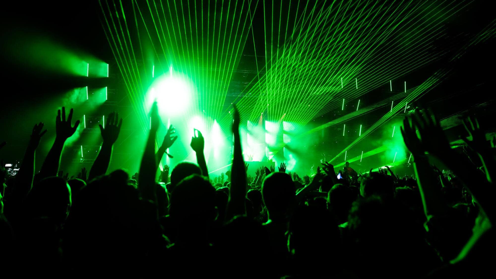 The Best Ibiza Parties: Top Events & Must-Visit Party Spots 2 Back View of Audience With Arms Raised in Front of Stage at Music Concert - Image by Drazen Zigic on Freepik