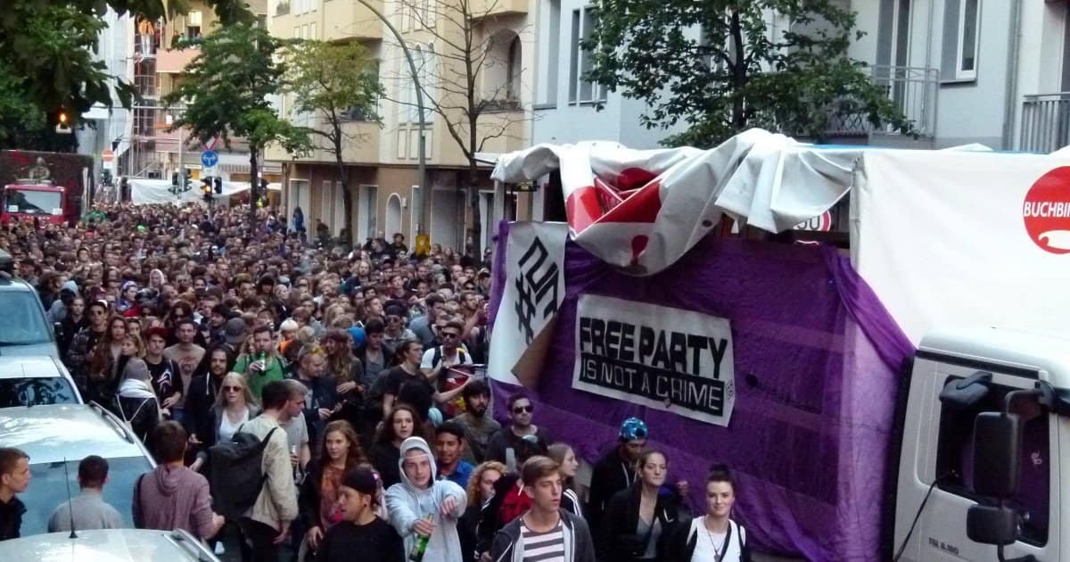 Crowd and a purple sound-system truck at the Fuckparade in Berlin, with a Free Party Is Not A Crime banner Crowd and a purple sound-system truck at the Fuckparade in Berlin, with a Free Party Is Not A Crime banner