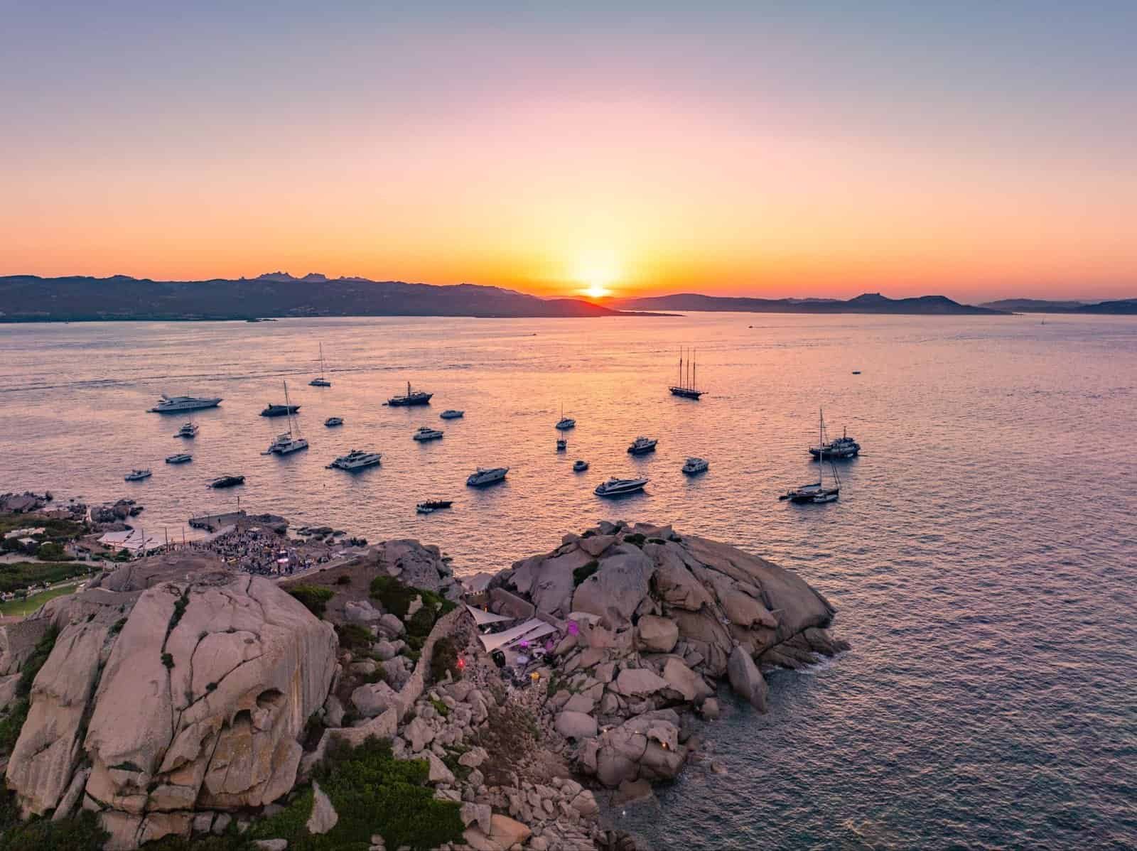 Phi Beach Sardinia at sunset with yachts anchored off the Costa Smeralda coast