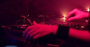 A DJ beatmatching two records in a club booth, the shared space behind every b2b set A DJ beatmatching two records in a club booth, the shared space behind every b2b set