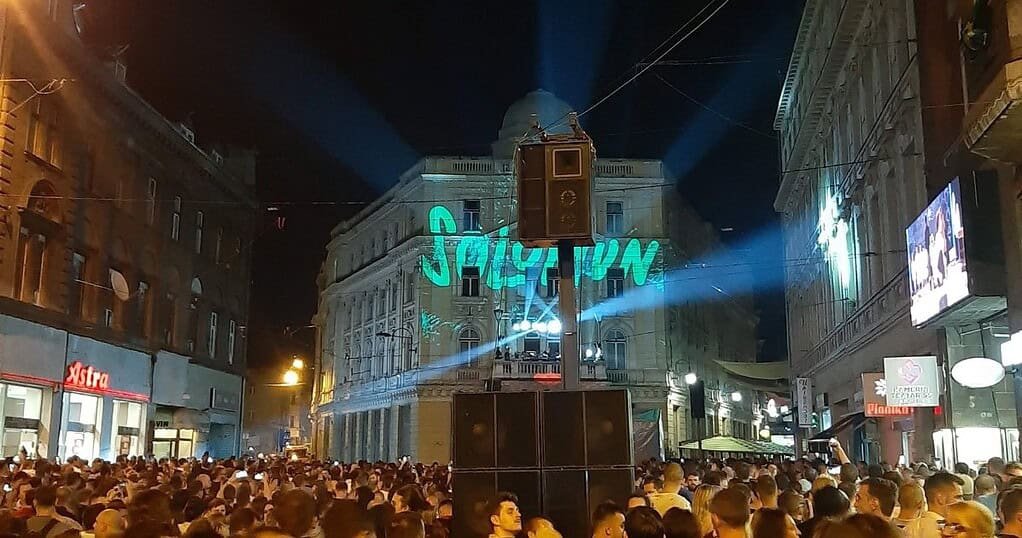 Crowd at Solomun's free street show in Sarajevo with his name projected on a building