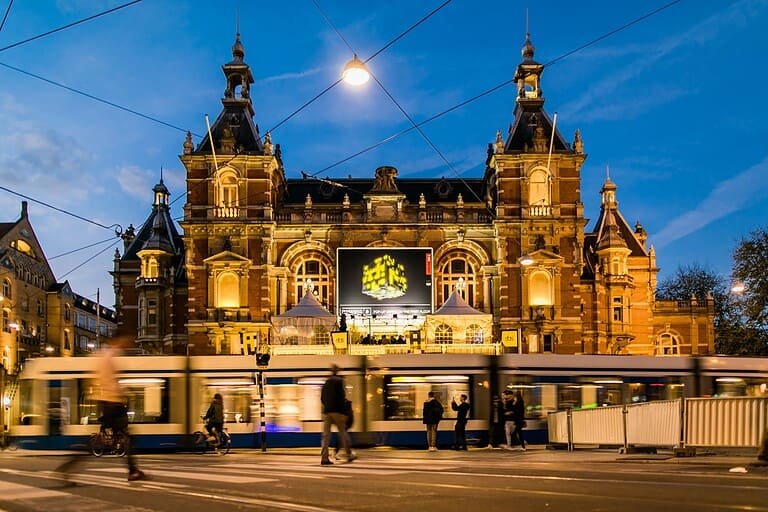 Amsterdam Dance Event at Leidseplein with the yellow ADE cube on the Stadsschouwburg screen at dusk Amsterdam Dance Event at Leidseplein with the yellow ADE cube on the Stadsschouwburg screen at dusk