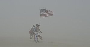 Burning Man participants walking through a dust storm on the Black Rock Desert playa in Nevada Burning Man participants walking through a dust storm on the Black Rock Desert playa in Nevada