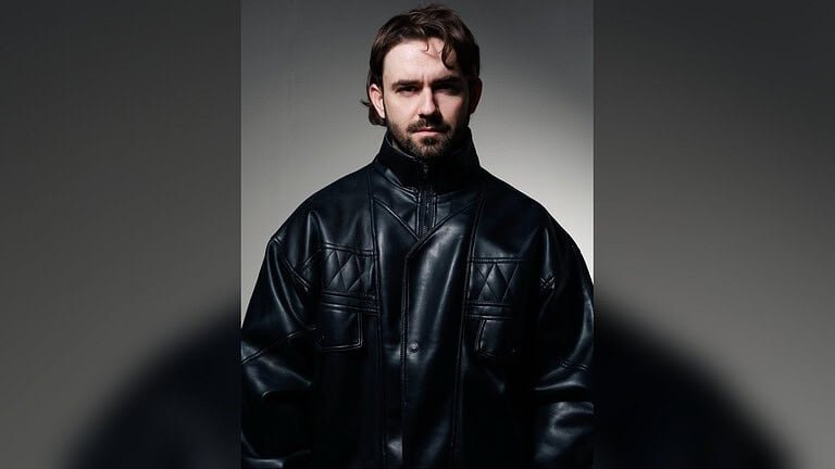 Studio portrait of Kevin Brauer in a black leather jacket