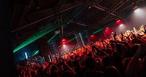 Crowd with raised hands under green lasers at an Amsterdam Dance Event club night Crowd with raised hands under green lasers at an Amsterdam Dance Event club night