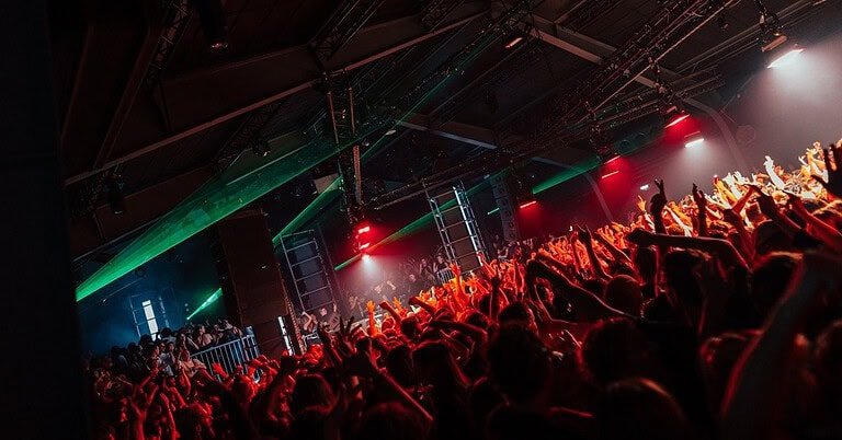 Crowd with raised hands under green lasers at an Amsterdam Dance Event club night Crowd with raised hands under green lasers at an Amsterdam Dance Event club night