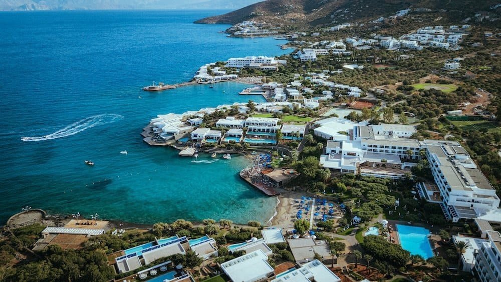 Nine Destination Festivals Worth Travelling For in 2026 and 2027 1 Aerial view of Elounda Bay Palace on the coast of Crete, home of Bateleur Festival