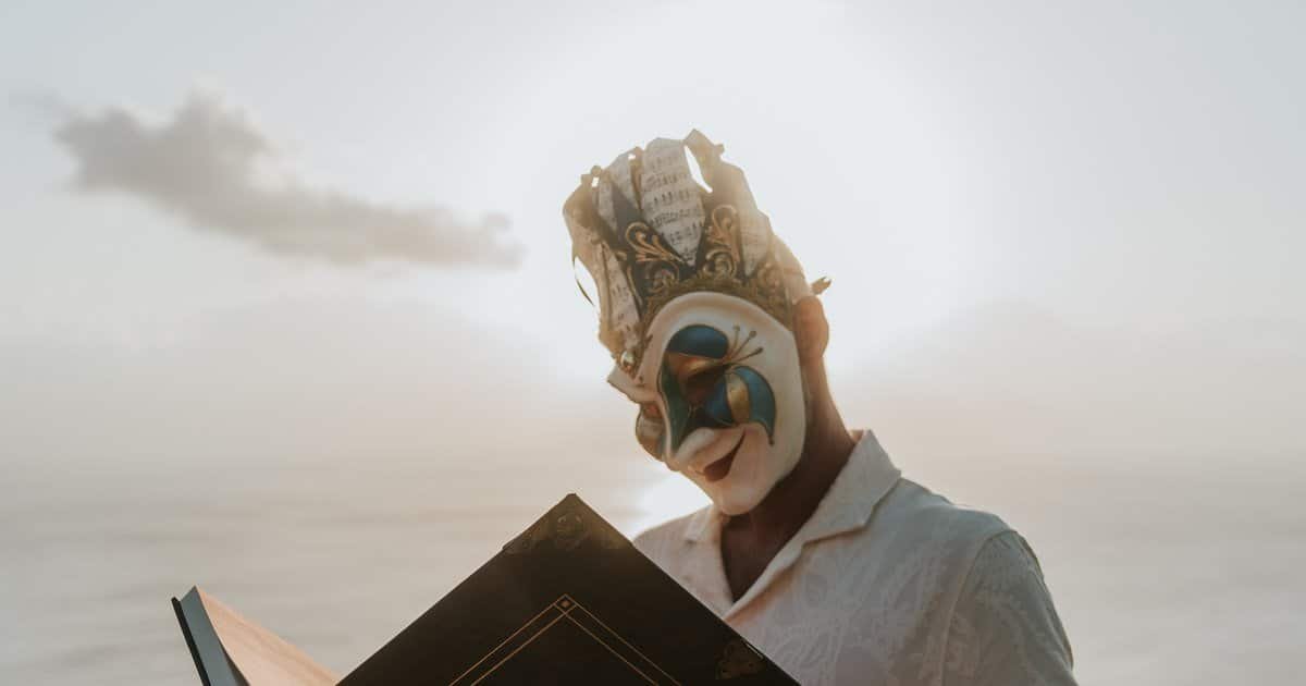 Boris Brejcha in his Joker mask reading the Becoming the Joker book on a clifftop Boris Brejcha in his Joker mask reading the Becoming the Joker book on a clifftop