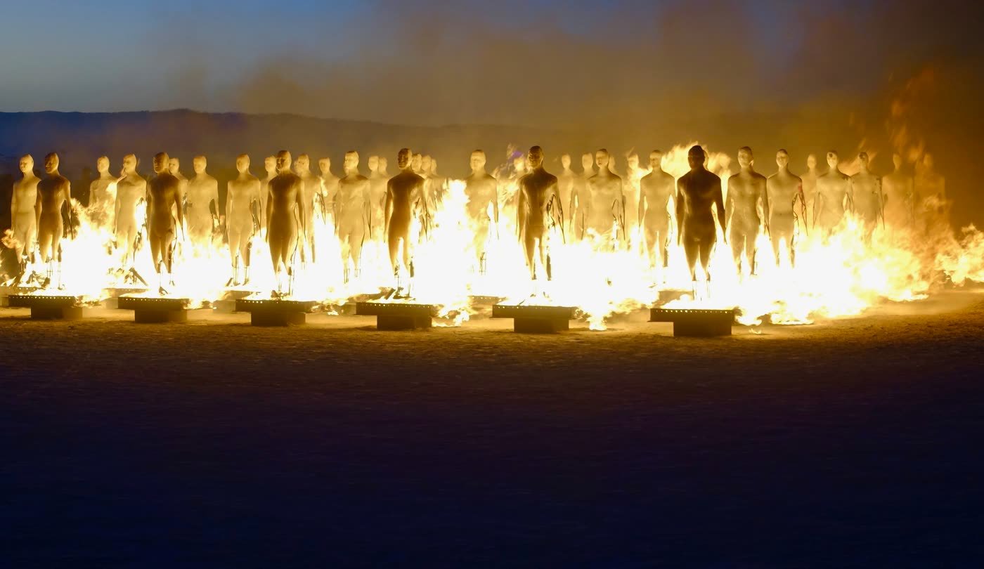 What Is Burning Man? The Event Explained, with 2027 Dates 2 Burners watching the Man burn at Burning Man in the Black Rock Desert