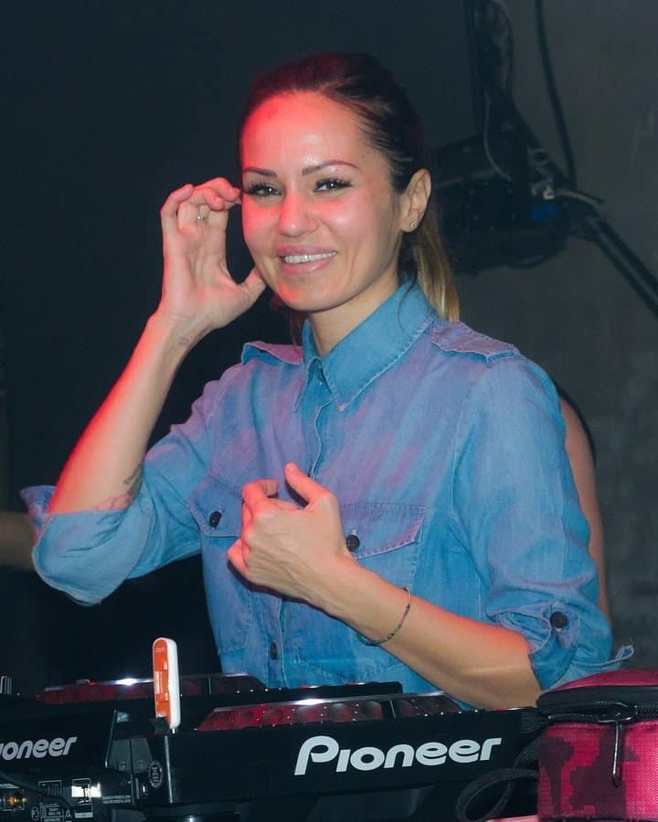 Highest-Paid Female Techno DJs 2026: Amelie Lens, Charlotte de Witte and 12 More 4 Deborah De Luca smiling behind Pioneer decks at Berlin's E-Werk