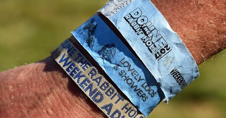 Fabric festival wristbands from Doune the Rabbit Hole worn on a wrist Fabric festival wristbands from Doune the Rabbit Hole worn on a wrist
