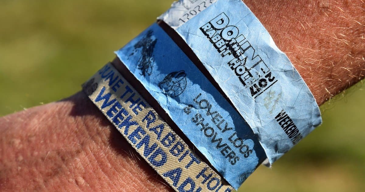 Fabric festival wristbands from Doune the Rabbit Hole worn on a wrist Fabric festival wristbands from Doune the Rabbit Hole worn on a wrist