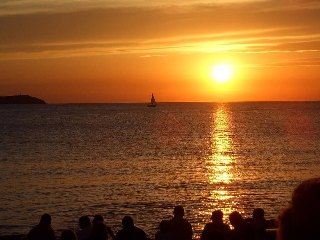 The Best Ibiza Parties: Top Events & Must-Visit Party Spots 1 Crowd watching the sunset at Café del Mar in San Antonio, a classic start to an Ibiza party night