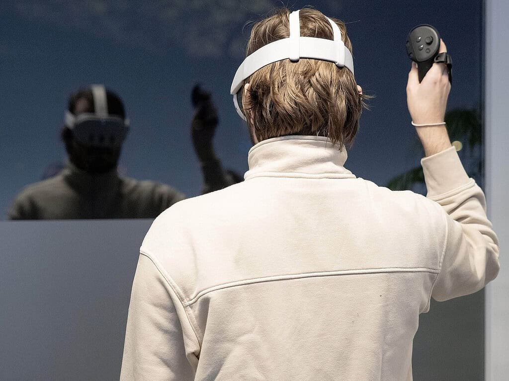 VR headset user raising a controller, the way people enter metaverse techno clubs