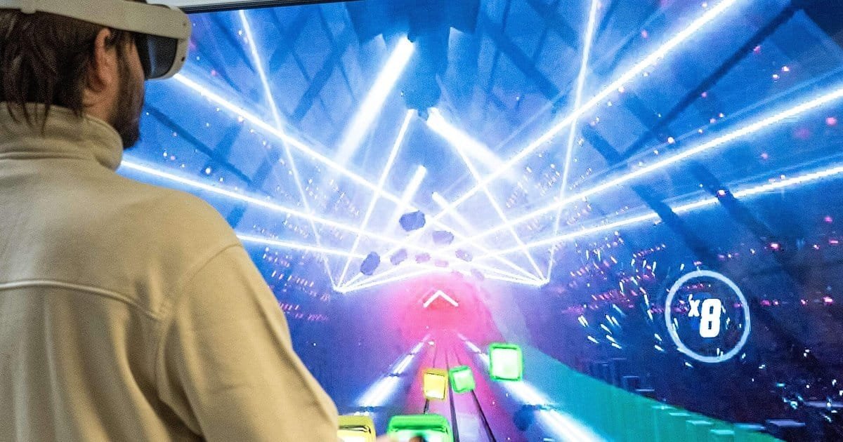 Person in a VR headset playing a music rhythm game with neon laser visuals, a taste of metaverse techno clubs