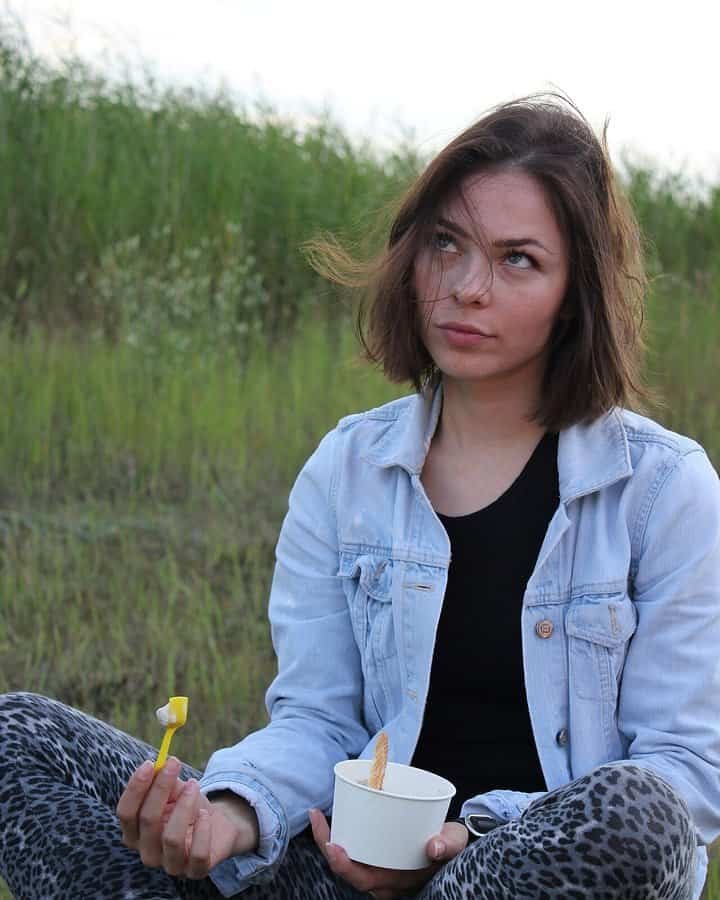 Highest-Paid Female Techno DJs 2026: Amelie Lens, Charlotte de Witte and 12 More 5 Nina Kraviz sitting on the grass in a denim jacket, photographed in 2012