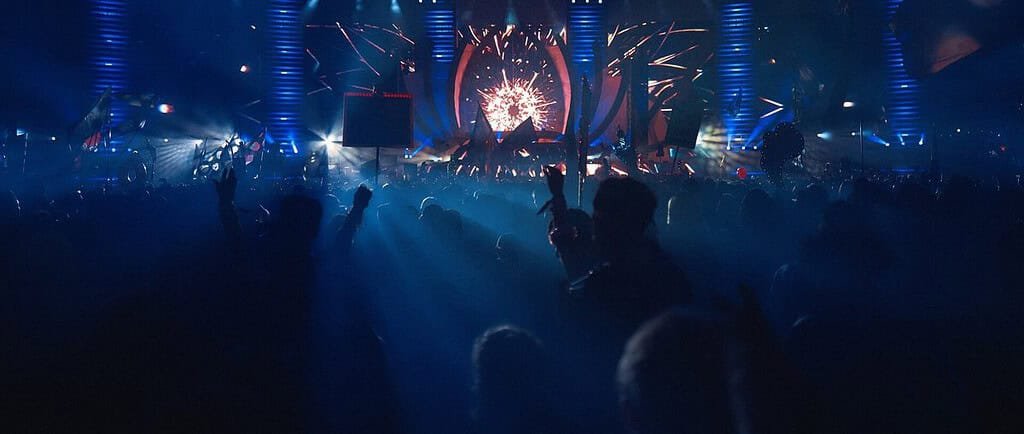 PLUR: The Heartbeat of Rave Culture 4 Crowd with raised hands under blue light beams at Electric Daisy Carnival Las Vegas, a festival built around PLUR