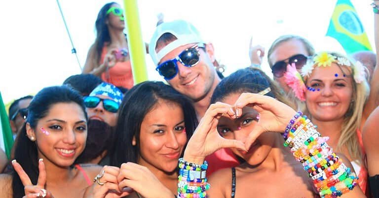 Smiling ravers wearing kandi bracelets make heart hands and a peace sign at TomorrowWorld festival, the spirit of PLUR Smiling ravers wearing kandi bracelets make heart hands and a peace sign at TomorrowWorld festival, the spirit of PLUR