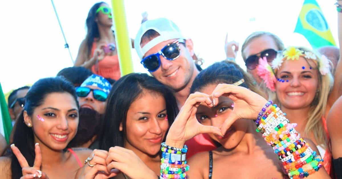 Smiling ravers wearing kandi bracelets make heart hands and a peace sign at TomorrowWorld festival, the spirit of PLUR Smiling ravers wearing kandi bracelets make heart hands and a peace sign at TomorrowWorld festival, the spirit of PLUR