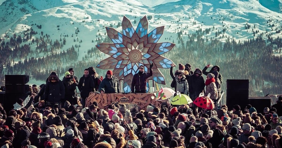 Rave On Snow crowd in front of a mountain stage on the Schattberg above Saalbach-Hinterglemm, one of Europe's winter techno festivals