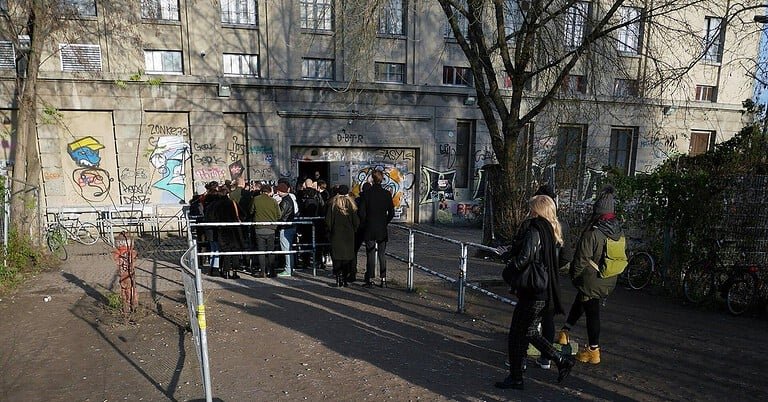 Clubbers in dark techno outfits queueing at the entrance of Berghain in Berlin Clubbers in dark techno outfits queueing at the entrance of Berghain in Berlin