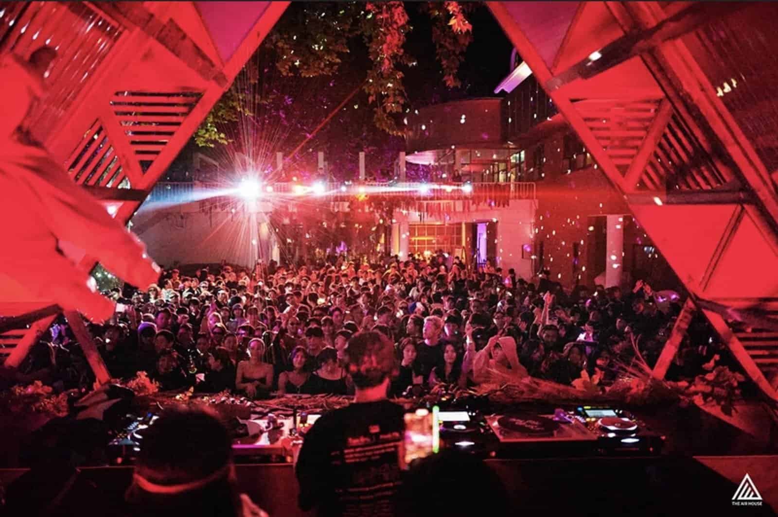 Nine Destination Festivals Worth Travelling For in 2026 and 2027 7 DJ booth and crowd under a red geometric stage structure at The Air House festival, South Korea