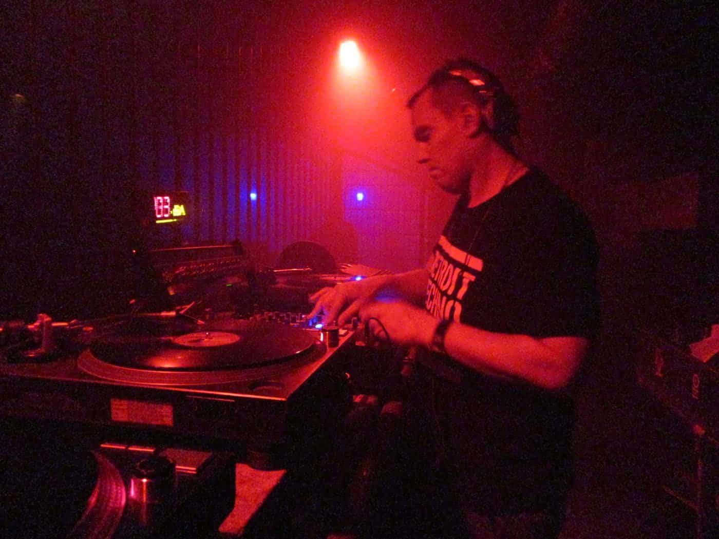 Inside Tresor Berlin: Photos, Videos and the Story of the Vault (2026) 2 A DJ playing vinyl in red light inside Tresor Berlin