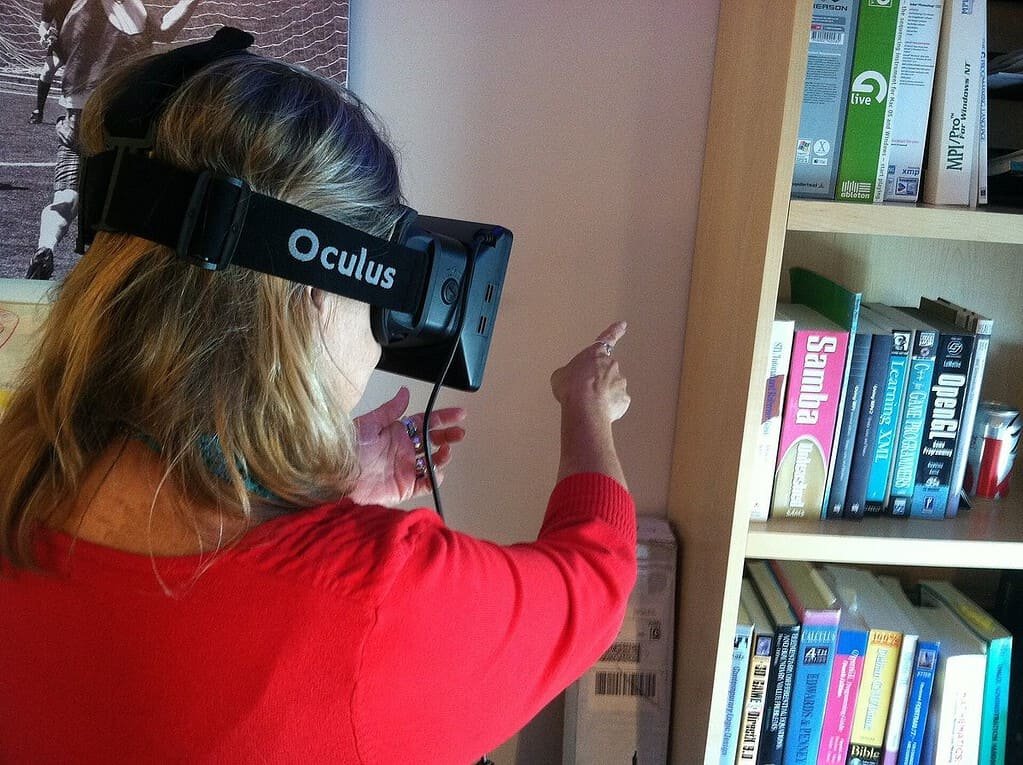 Woman using an Oculus Rift virtual reality headset at home, showing how VR makes nightlife more accessible