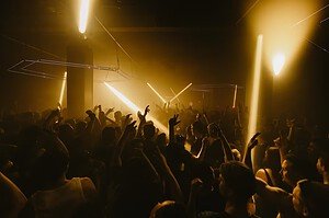 Warehouse Elementenstraat club in Amsterdam, crowd with raised hands under amber light beams